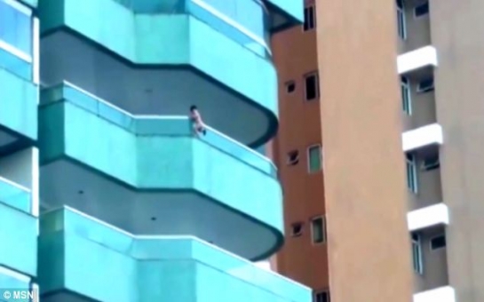 Toddler clambered out over fifth floor balcony - VIDEO