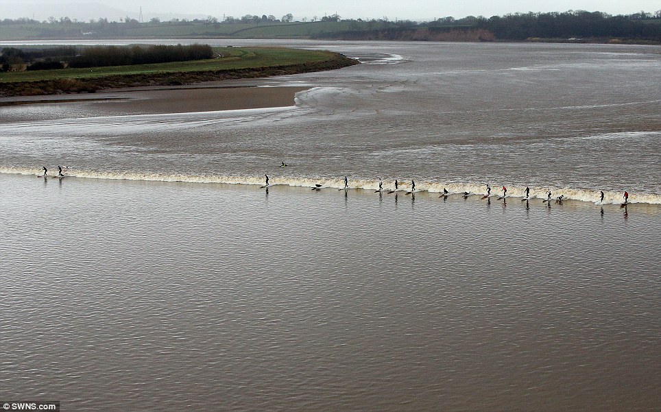 Surfers brave the cold for a group ride on a 20 mile wave - PHOTO