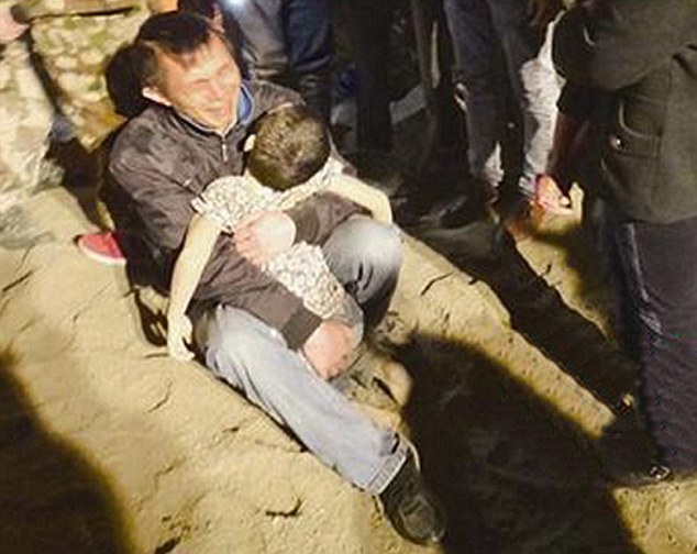 Father cradles his six-year-old son after he was buried alive by lorry