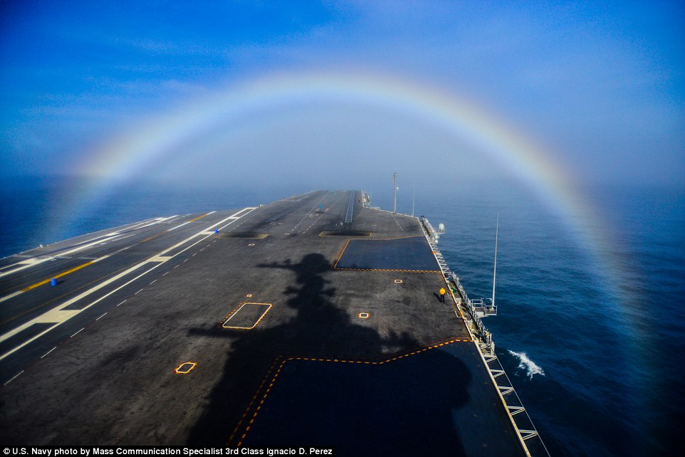 Photographer captures moment US Navy aircraft carrier steams through a rainbow