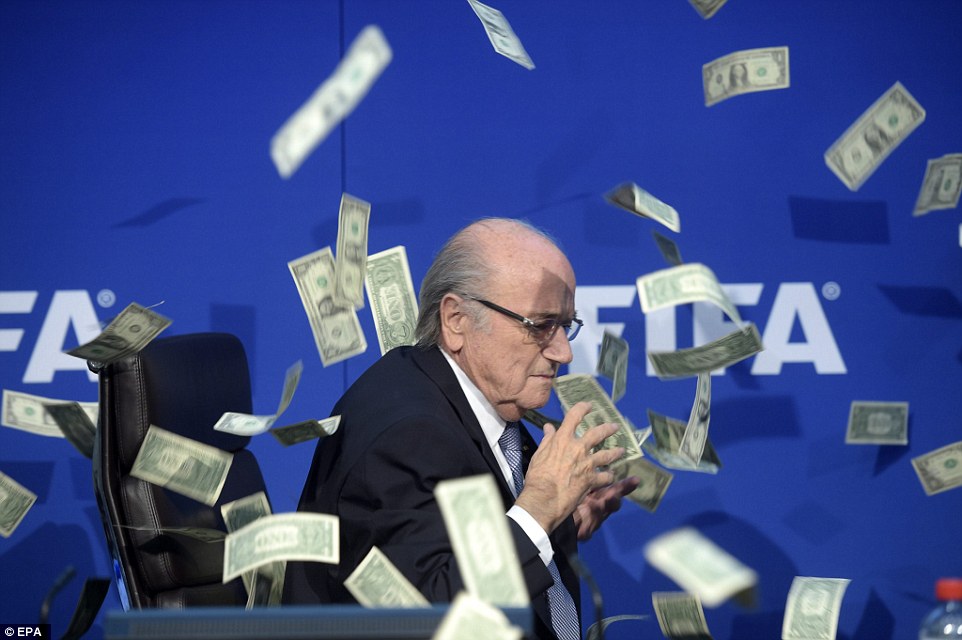 Shamed FIFA president Sepp Blatter is showered in fake dollar bills