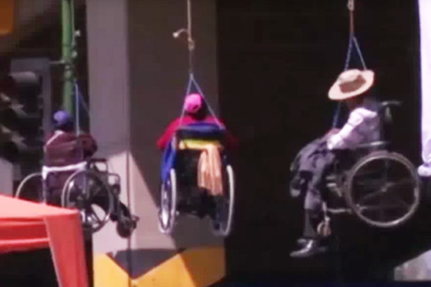 Wheelchair users dangle from bridge in extreme anti government protest