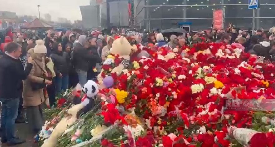 Жители Москвы несут цветы к стихийному мемориалу у «Крокус Сити Холла»
