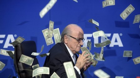 Shamed FIFA president Sepp Blatter is showered in fake dollar bills