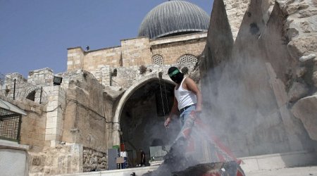 Masked Palestinians clash with Israeli police at Jerusalem mosque