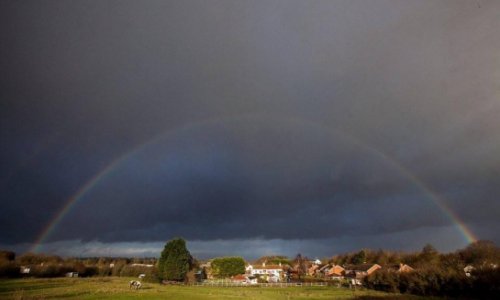 A rainbow emerges just before 80mph winds devastate Britain