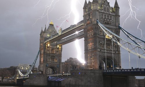 Lightning strikes over London's iconic Tower Bridge, creating an exhilarating scene - PHOTO