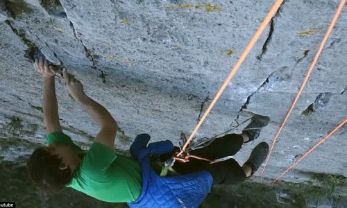 Fearless free climber clutches on by his fingertips to scale 2,500ft rock face - PHOTO