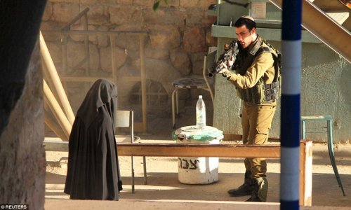 Israeli soldier pointed his rifle at veiled teenage Palestinian student...