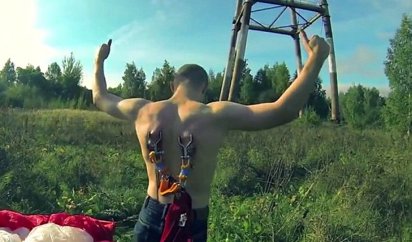 Extreme bungee jumpers attach metal hooks on harness to their skin - PHOTO