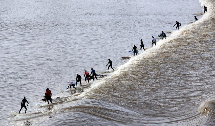 Surfers brave the cold for a group ride on a 20 mile wave - PHOTO Surfers brave the cold for a group ride on a 20 mile wave - PHOTO