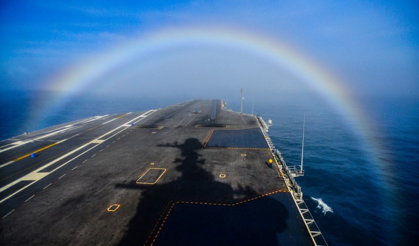 Photographer captures moment US Navy aircraft carrier steams through a rainbow Photographer captures moment US Navy aircraft carrier steams through a rainbow