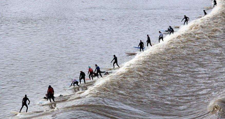 Surfers brave the cold for a group ride on a 20 mile wave - PHOTO