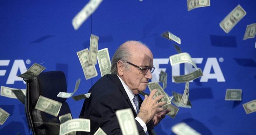 Shamed FIFA president Sepp Blatter is showered in fake dollar bills